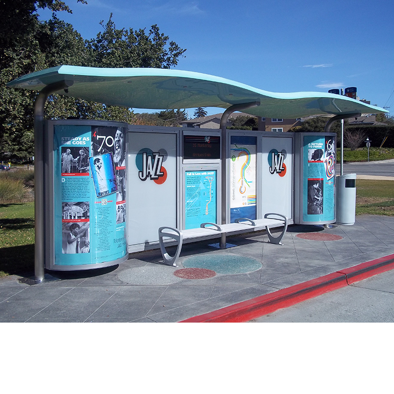 A side view of the front of a custom bus shelter with Jazz history and design, bench seating and a trash can close by