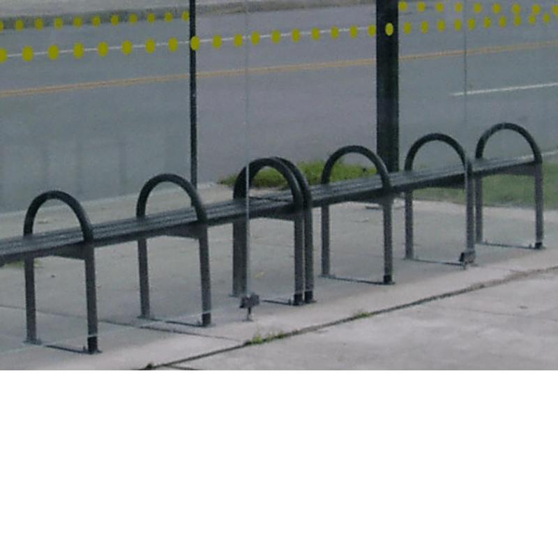 Bench seating inside a bus shelter with rounded bars separating each seat along the bench.
