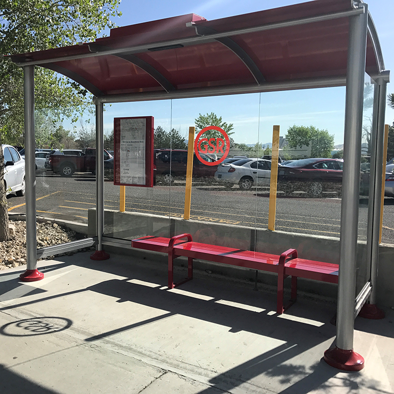 A signa bus shelter is seen from the front right with bench seating, a rider information display on the back left panel and a custom GSR logo on the back.