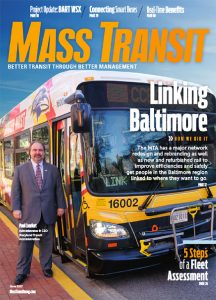 Cover of Mass Transit magazine with a bus on the front and a man standing next to it.