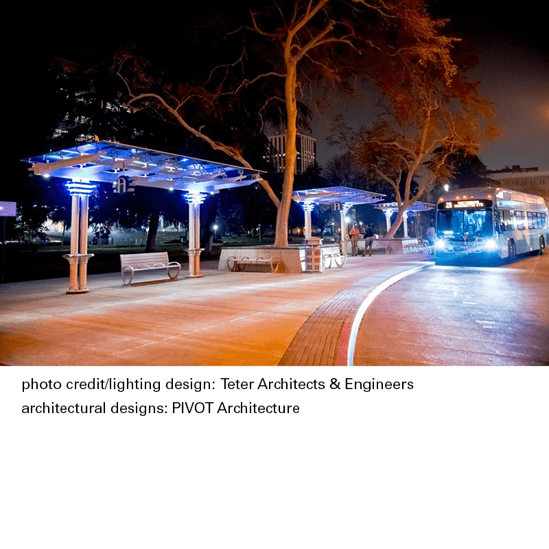 Bus shelter seen at night at a transit center with a bus pulling up on the right and a caption at the bottom with photo credit and architecture credit.