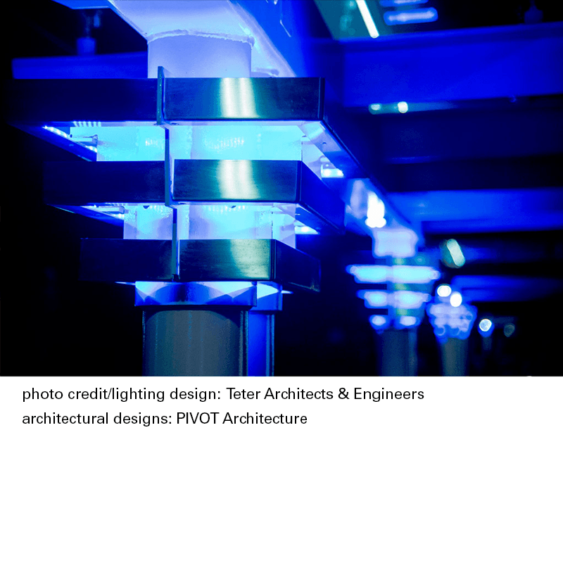 Lighting on the posts of a bus shelter with a caption below giving photo and architecture credit.