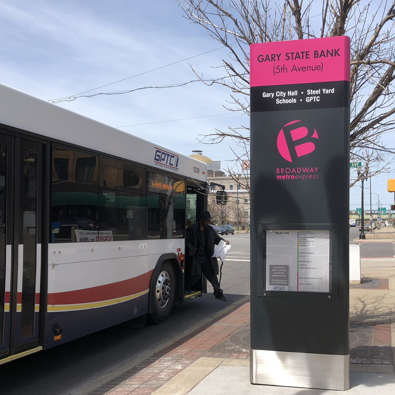 A bus next to a bus transit rider information display.