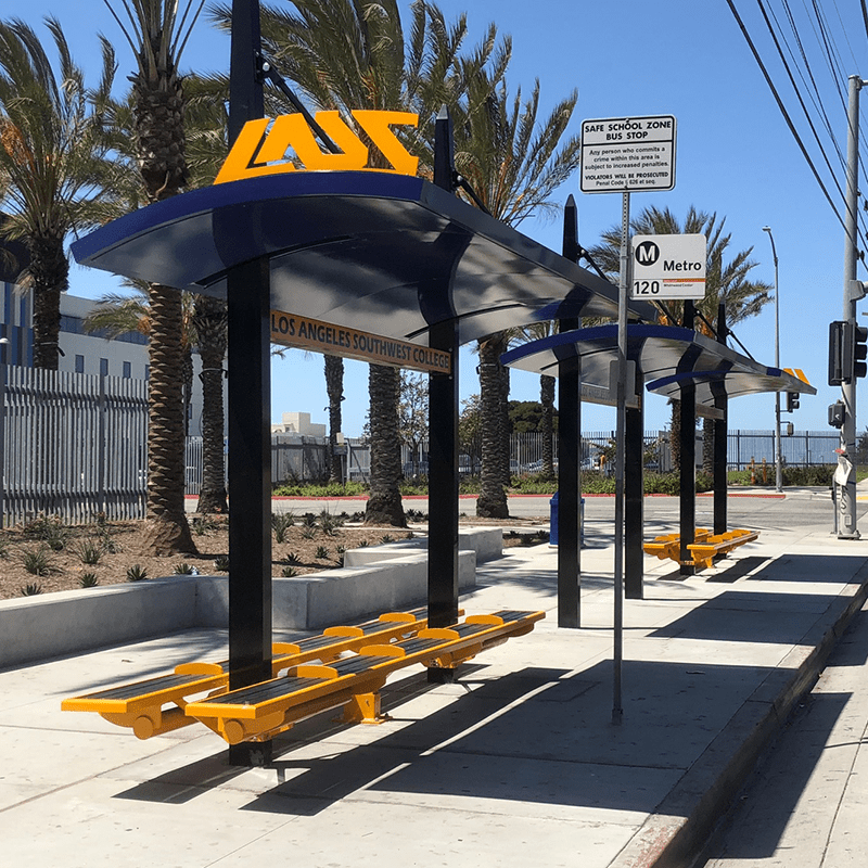 Two bus shelters are seen side by side with double sided benches at each shelter.