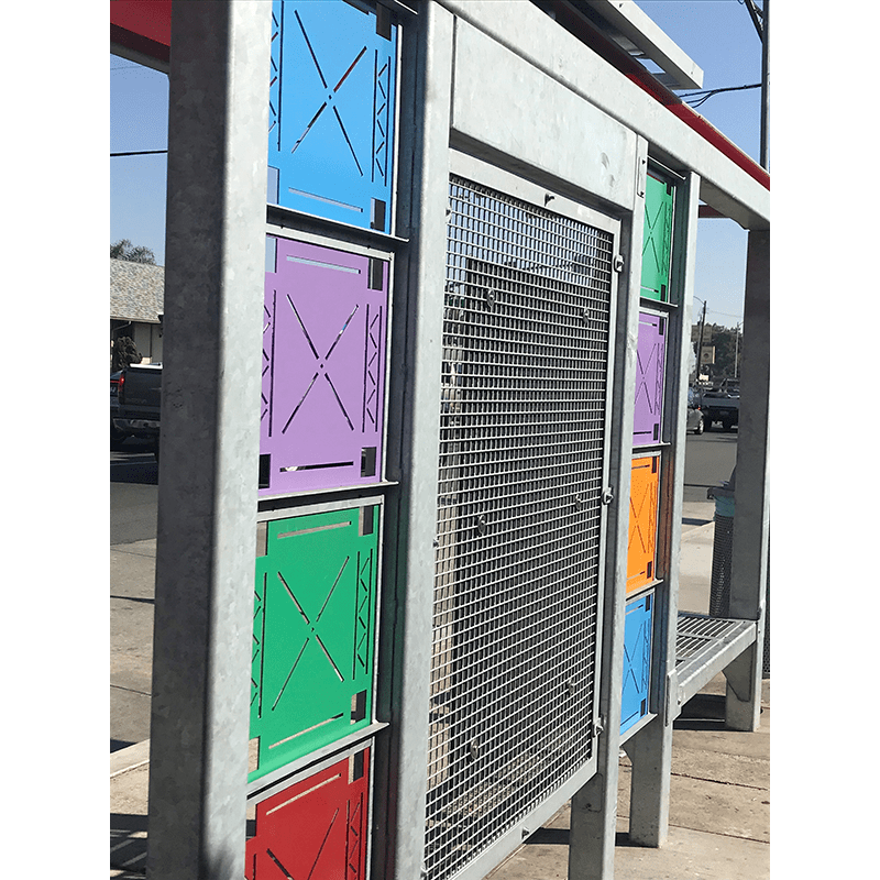 Colorful custom built bus shelter with colored metal squares on the back wall of shelter