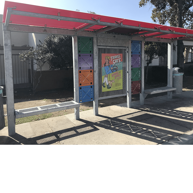Right side view of a two bench bus shelter with color square designs and a single center advertising display