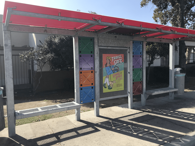 Red roof and double bench bus shelter with center advertising display
