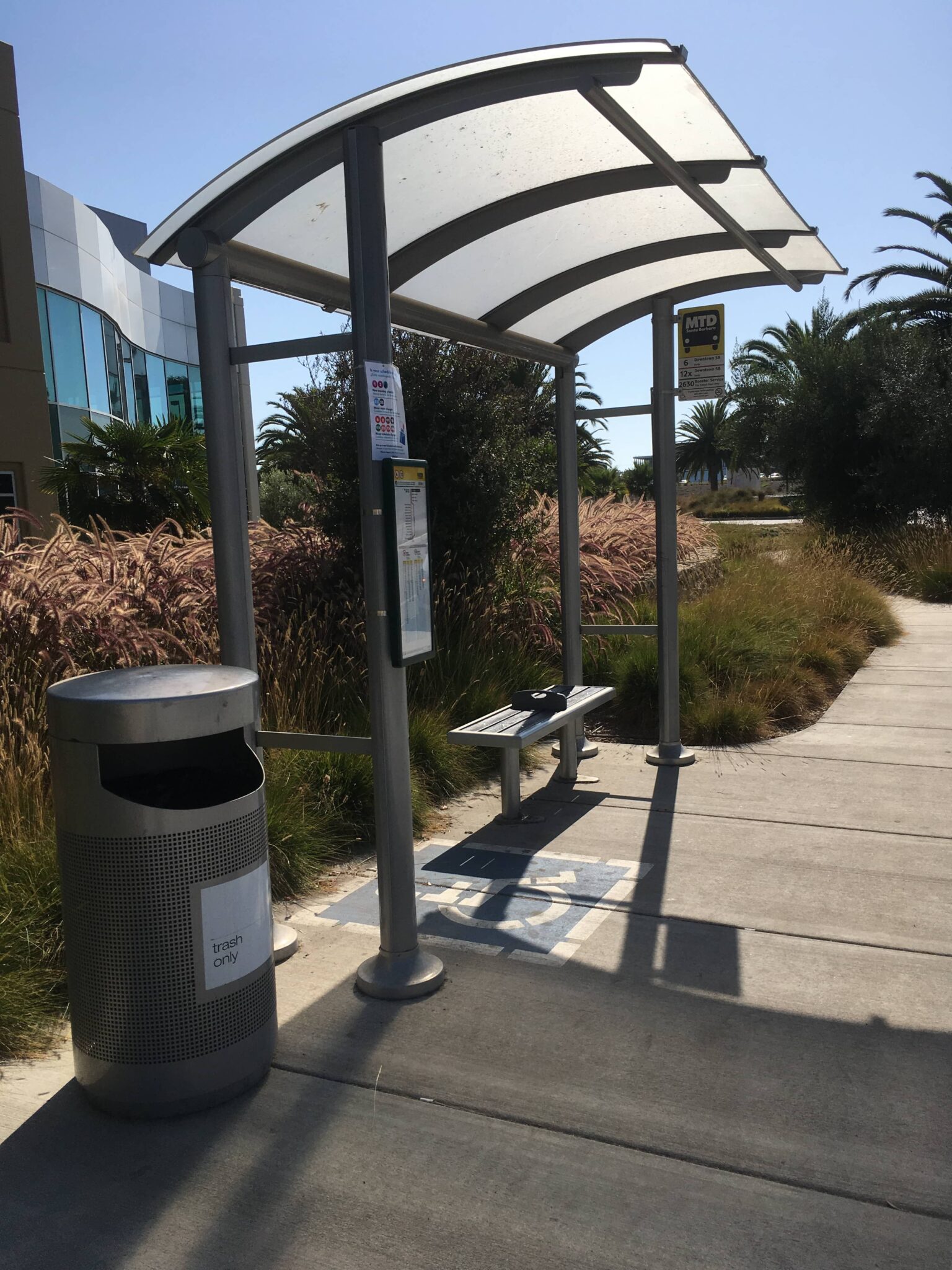 Right side view of a signature sunset bus shelter that provides disabled rides a place to wait for the bus