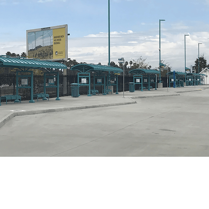Bus shelters at a transportation hub with benches and trash receptacles at each.