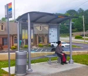 photo of woman sitting at MARTA bus shelter in neighborhood A bus shelter is seen with a woman waiting inside the shelter on the bench seating.