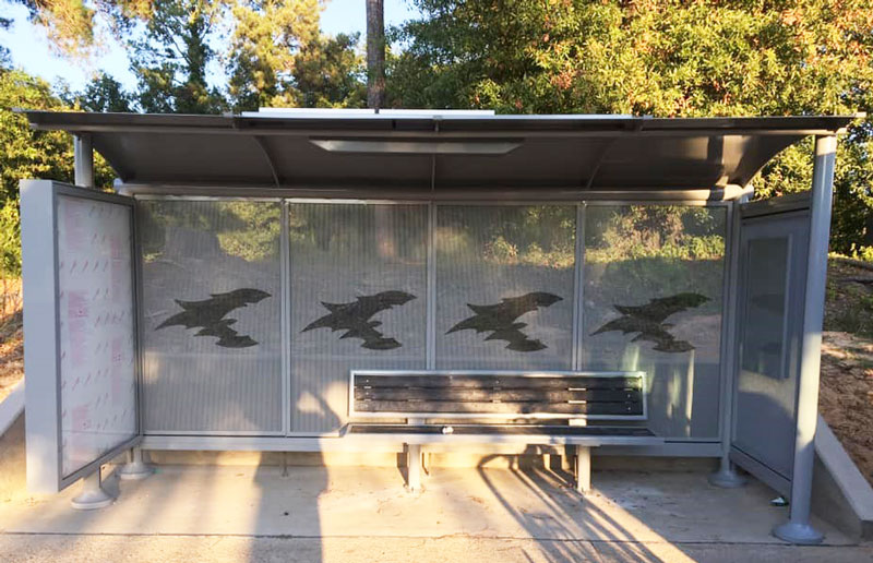 Front view of a comet bus shelter with rider information display, advertising display and bench seating