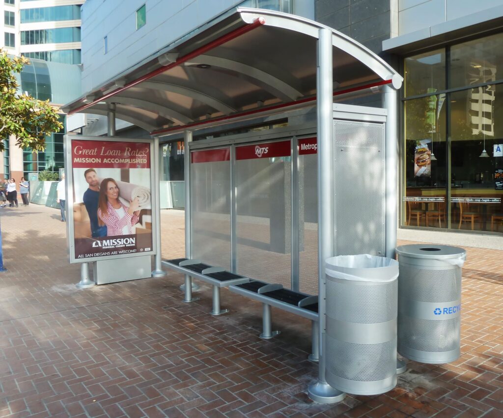 Left side view of a city bus shelter that includes recycling and trash receptacles