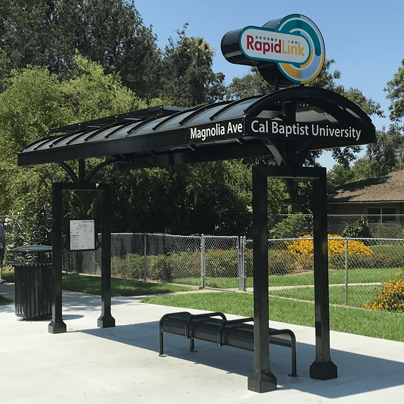 Left side view of a RapidLink station with trash receptacle, station name and rider information display