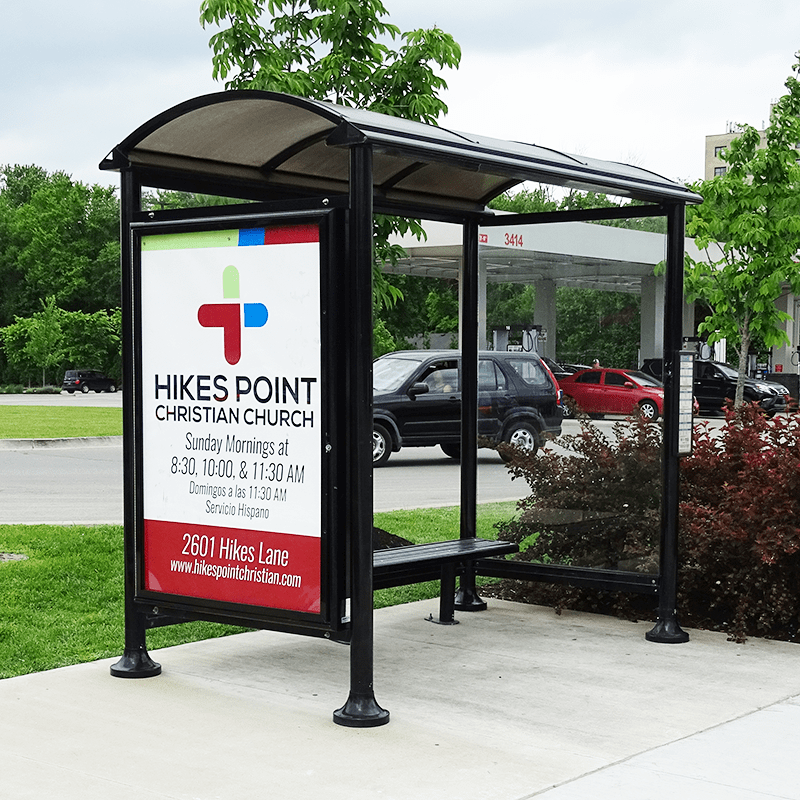 A bus shelter seen from the front left side with a Hikes Point advertisement on the advertising display on the left panel.