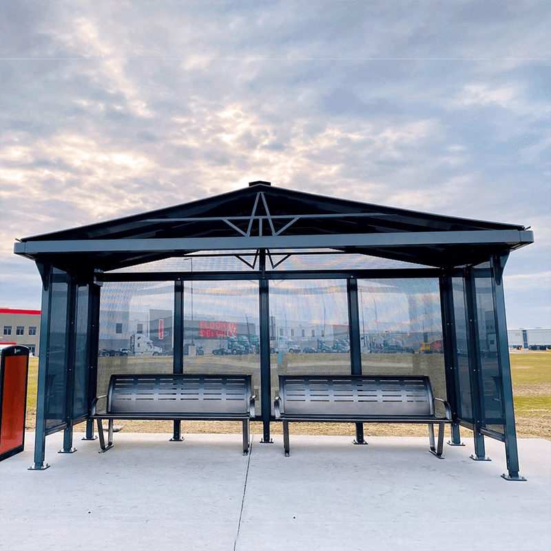 A bus shelter with two benches under the shelter and a trash receptacle on the outside left.