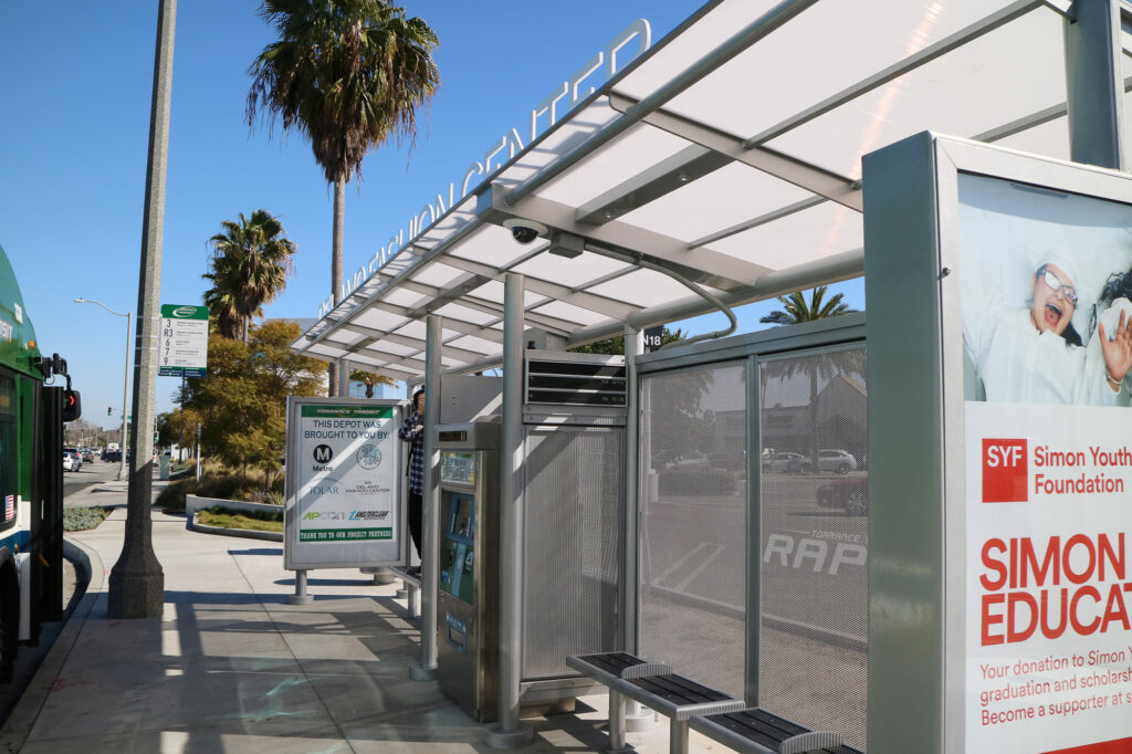Transit center shelter includes benches and a ticket machine in the middle