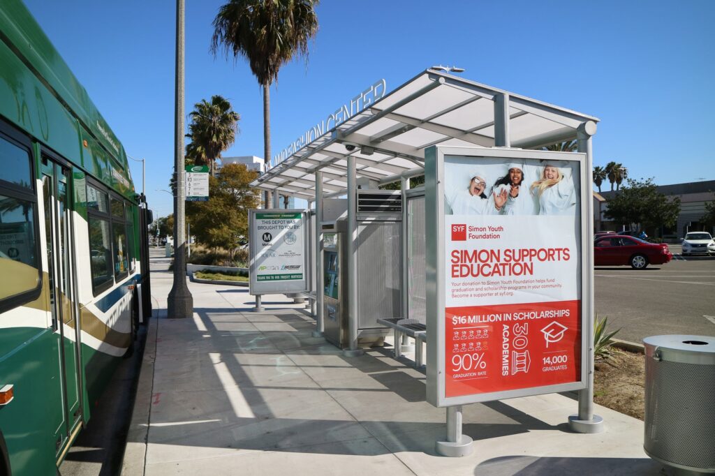 Transit center shelter side view with advertising displays on either side and bus information display
