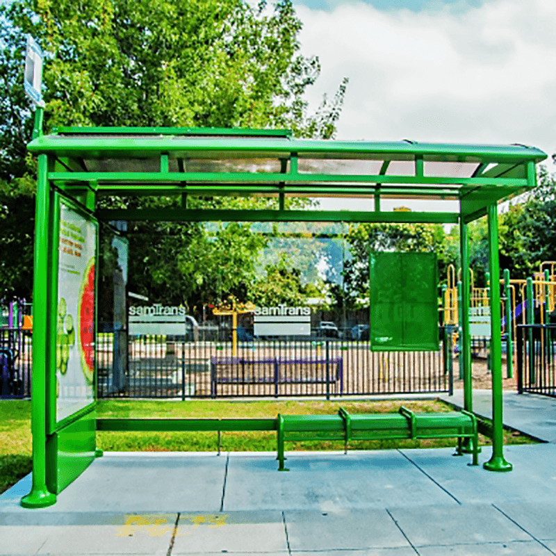 A bus shelter with bench seating, a left side panel with double sided advertising panel, glass siding with a custom logo and a rider information display on the back right panel.