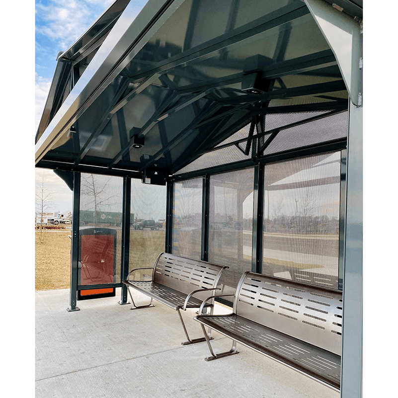 A bus shelter is seen from the right side front with two benches inside and a trash receptacle on the outside left.