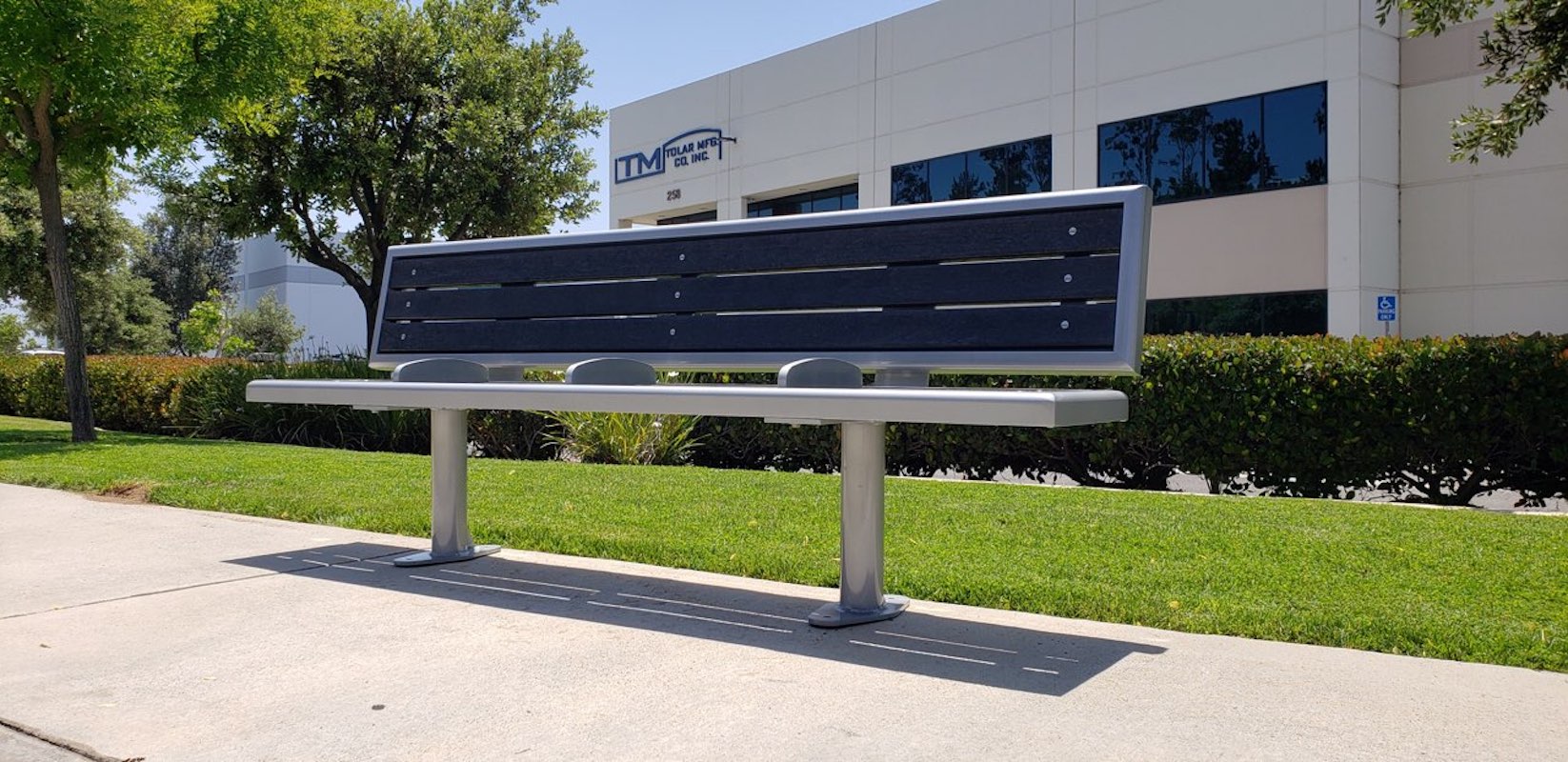 Front view of a bench with a back rest and three slat design and three dividers for passengers