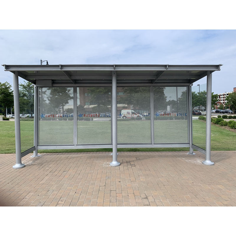 A bus shelter is seen from the front with a custom text on the back panels.