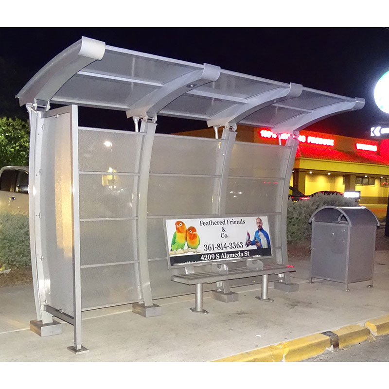 A signa crescent bus shelter seen from the front left with a bench with an advertising display on the back rest of the bench and a trash receptacle on the outside right.