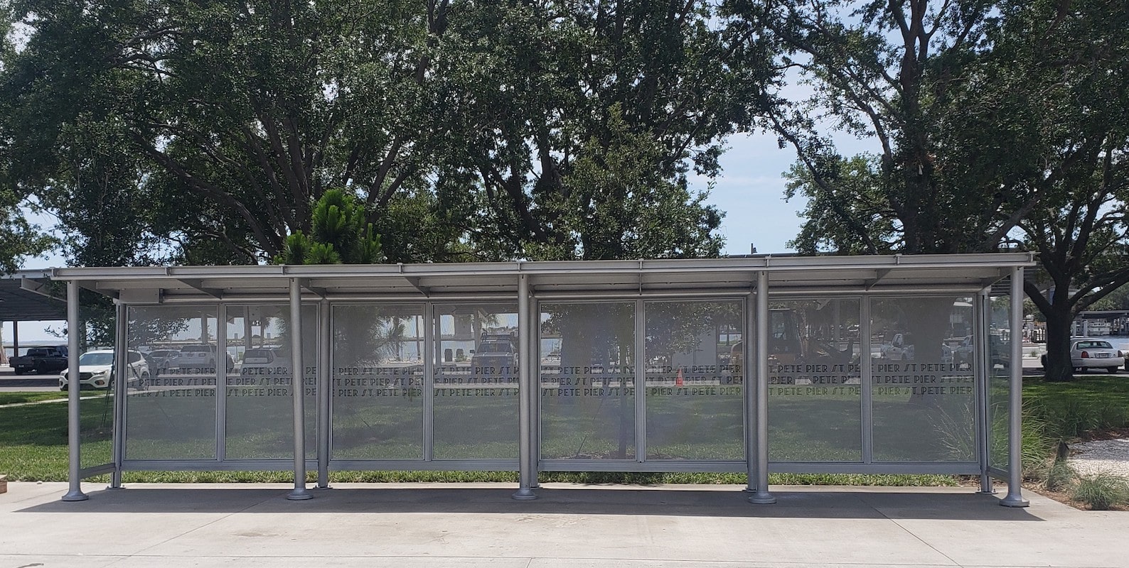 A sunset empire bus shelter seen from the front with a custom back panel with the stop's name.