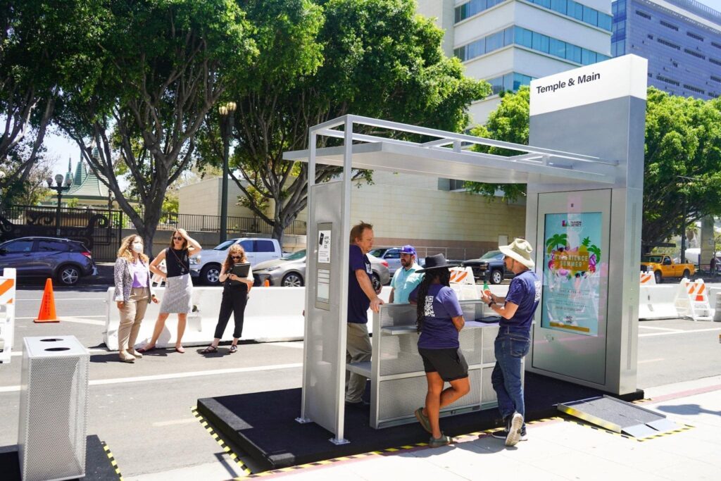 A two sided bus shelter with standing counters, advertising display and wheelchair access.