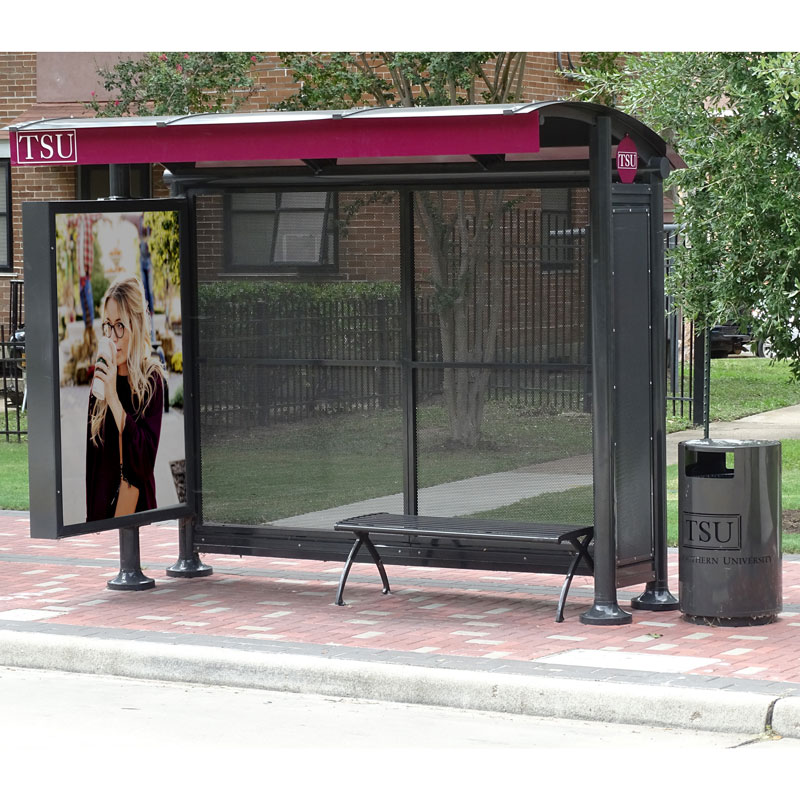 A siga sunset bus shelter is seen from the front with an advertising display, bench seating and a TSU trash receptacle on the outside right.