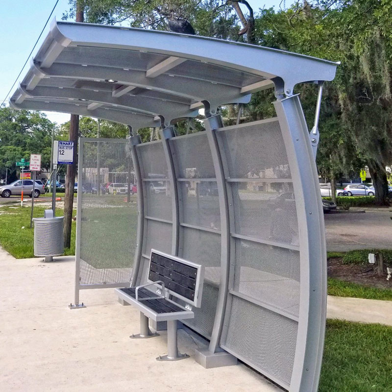 A signa crescent bus shelter with an arched back and roof for a model design and a bench with two seats.