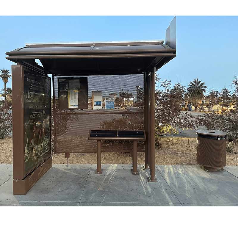 A sierra bus shelter is seen from the front with an advertising display on the left, a standing bench on the inside and a trash receptacle on the outside right.