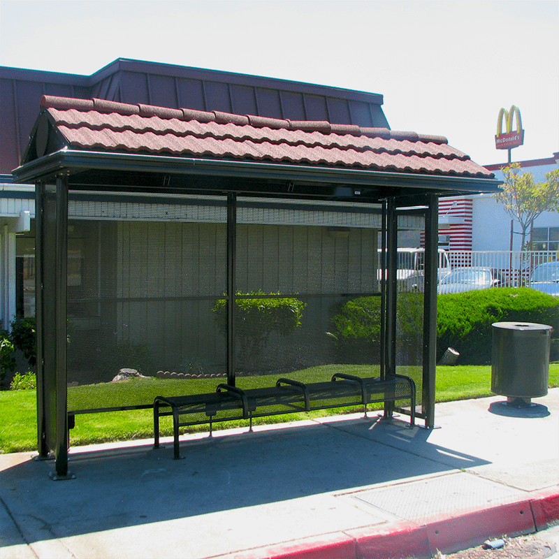 Shingled roof sierrna bus shelter with trash receptacle on the left of the shelter