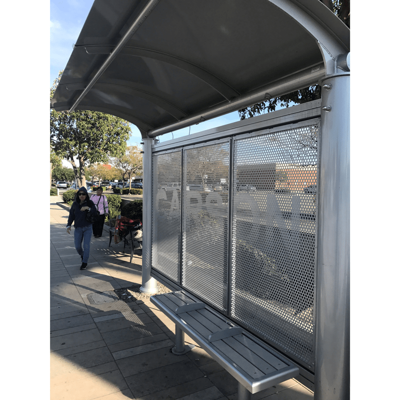 Left side view of a Signa Sunset bus shelter with a bench and custom Carson printed on back wall of shelter