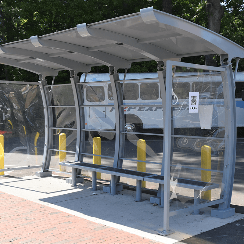 Left facing signa crescent bus shelter with three sides of covering and a metal roof