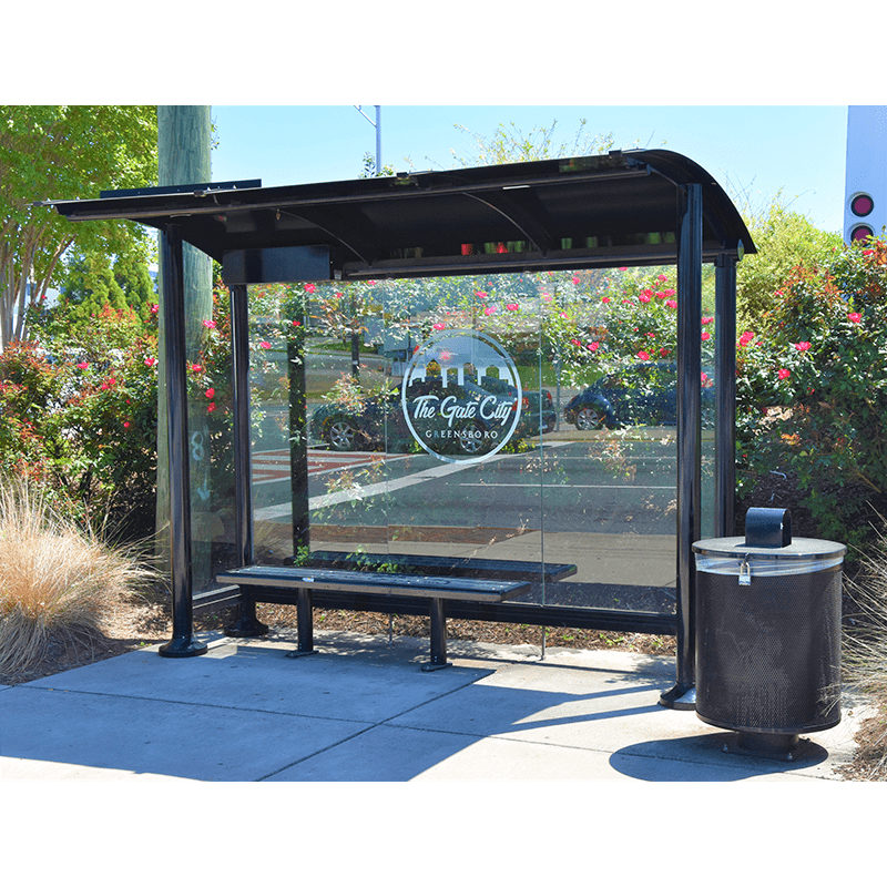Front view of a custom signa sunset bus shelter including a bench, trash receptacle and custom city logo