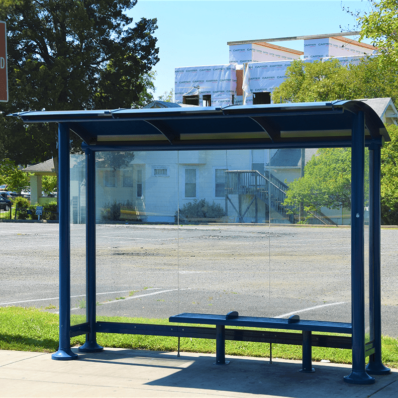 Front view of a Tolar signa sunset bus shelter offering shade, a place to sit and glass siding