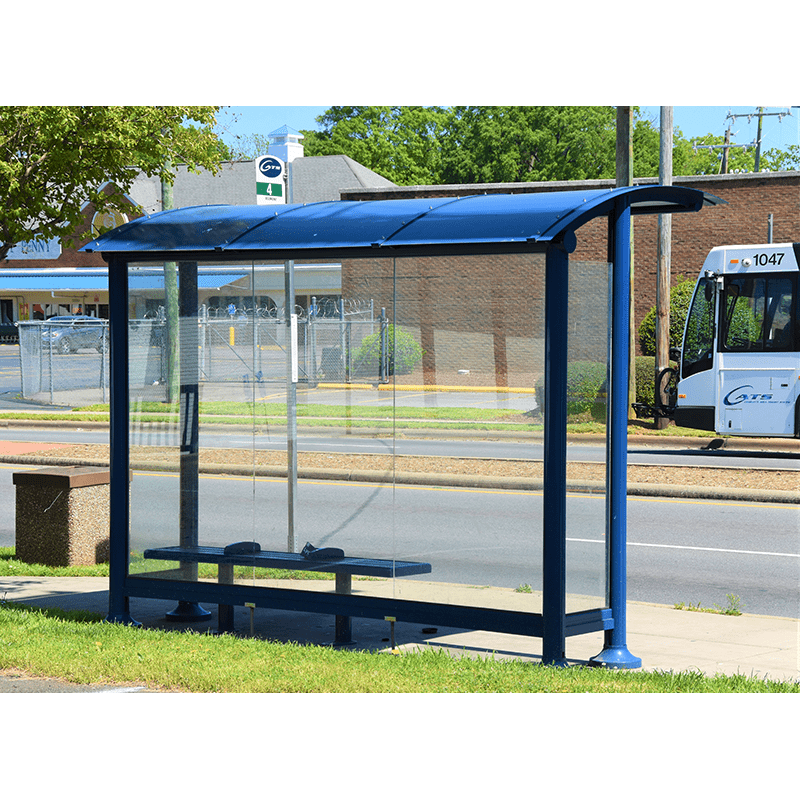rear view of a blue signa sunset bus shelter with a single bench and all glass siding