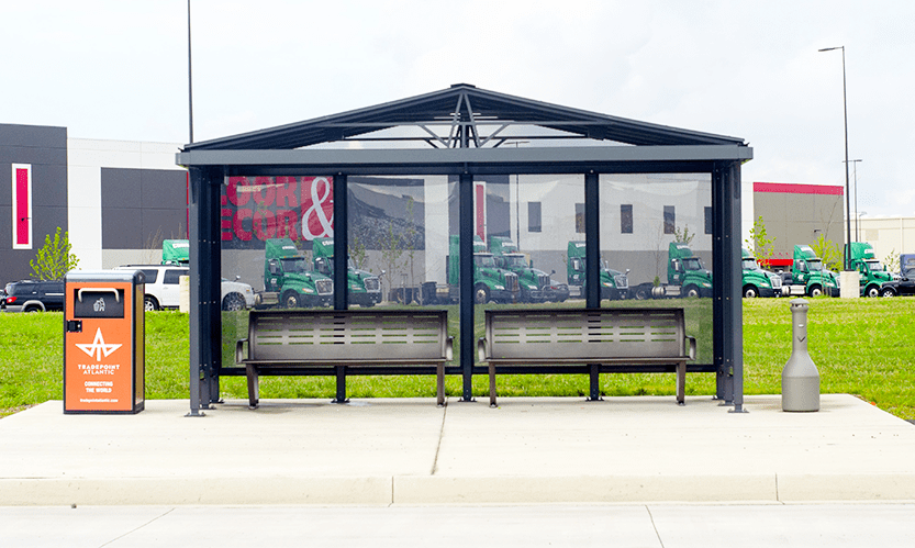 A head on view of a Baltimore bus shelter with two benches, a smoking receptacle and a trash receptacle on the opposite side