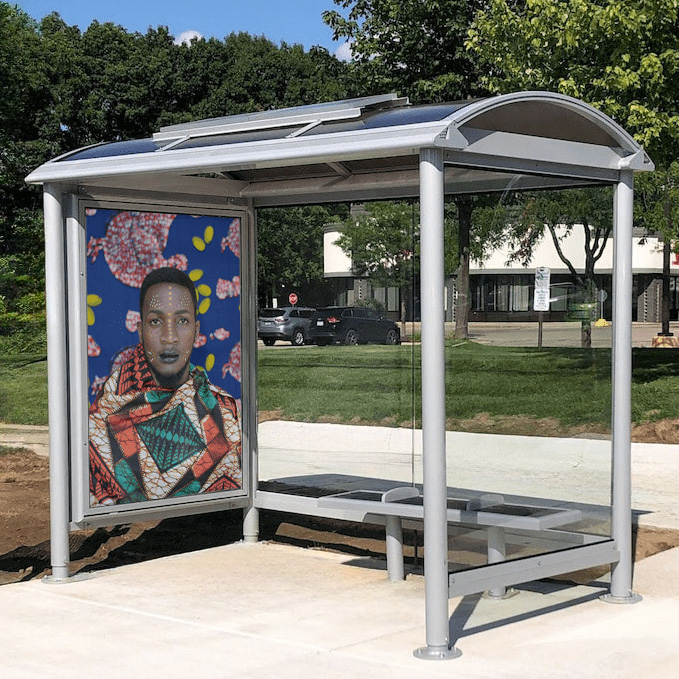 Euro Series Bus Shelter displays artwork inside the shelter with bench seating and glass siding