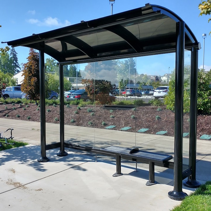 Signature series bus shelter with an arched roof, bench seating and glass back wall