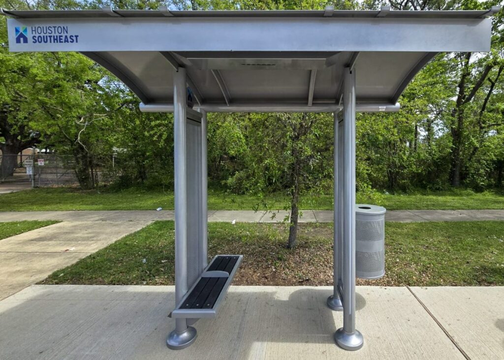 A sunset series bus shelter seen from the front in Houston, TX with bench seating for two and a trash receptacle