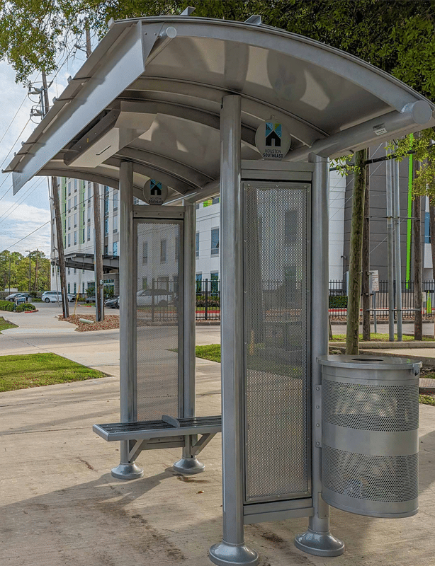 Right side view of a bus shelter in Houston with bench seating for two and a trash receptacle