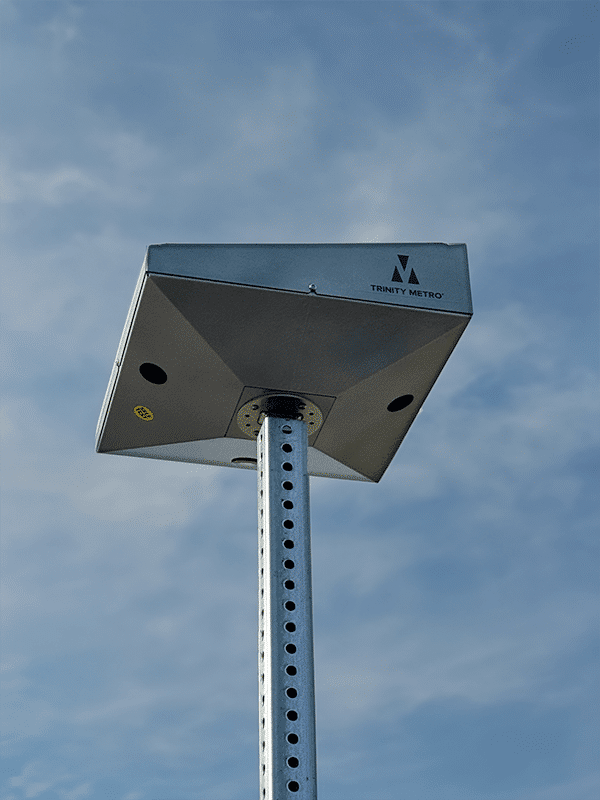 A pole holds a solar panel for lighted bus shelters at night