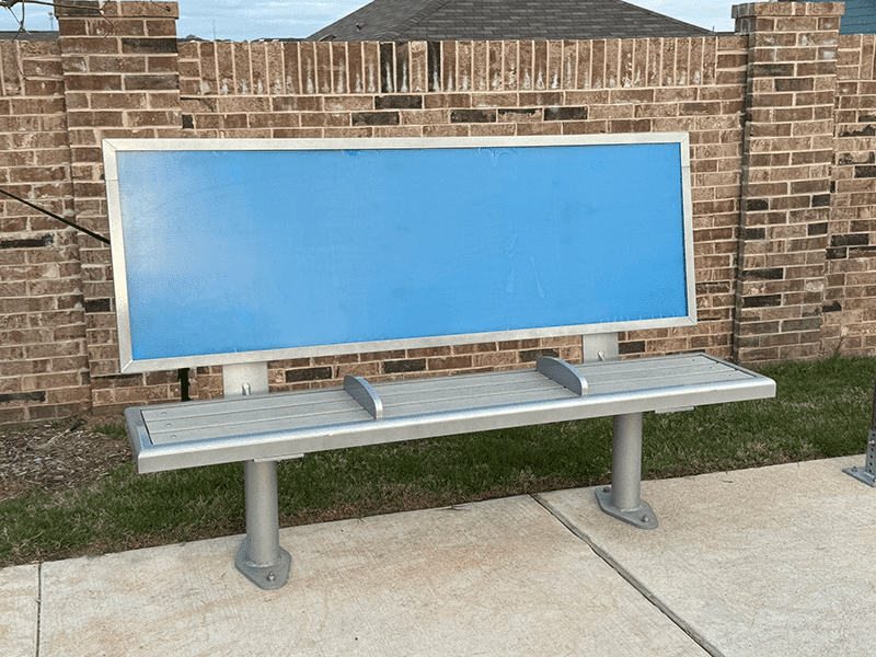 A bus shelter bench is seen from the front with three seats and an advertising backrest.