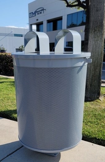 A trash receptacle is seen from the right side with two arch coverings on top to protect what is inside.