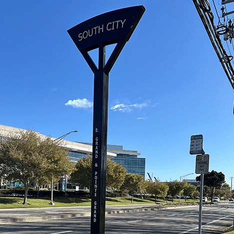 A bus stop post is seen with signage reading South City on top.