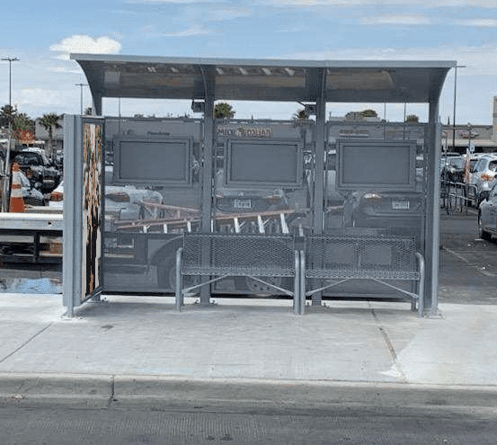 Forward facing bus shelter for SunMetro in El Paso, Texas with two benches and large advertising display