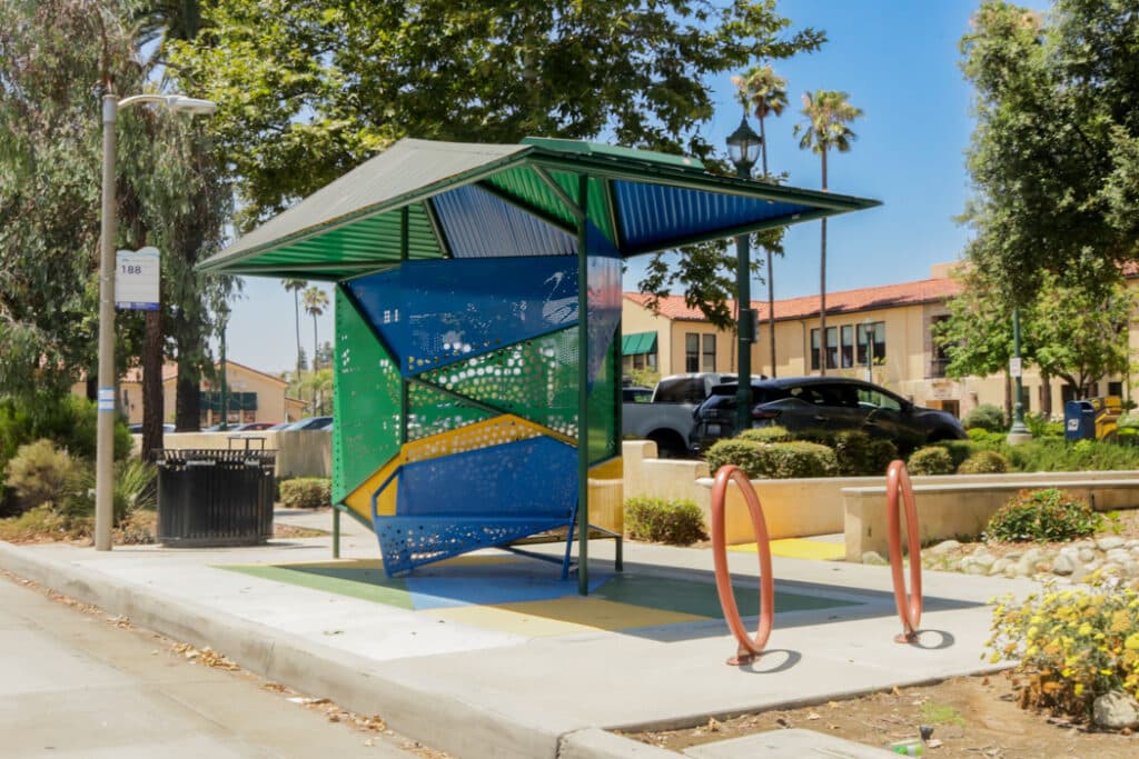 dynamic shelter-style bus stop with blue, yellow and green powder coated aluminum